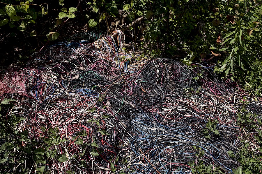 8. Piles of wire casings stripped for metal recycling adjacent to riverfront habitations in East London, June 2015